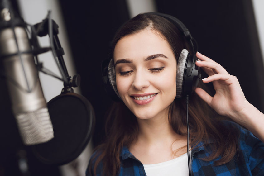 Eine junge Profi-Sprecherin spricht im Tonstudio